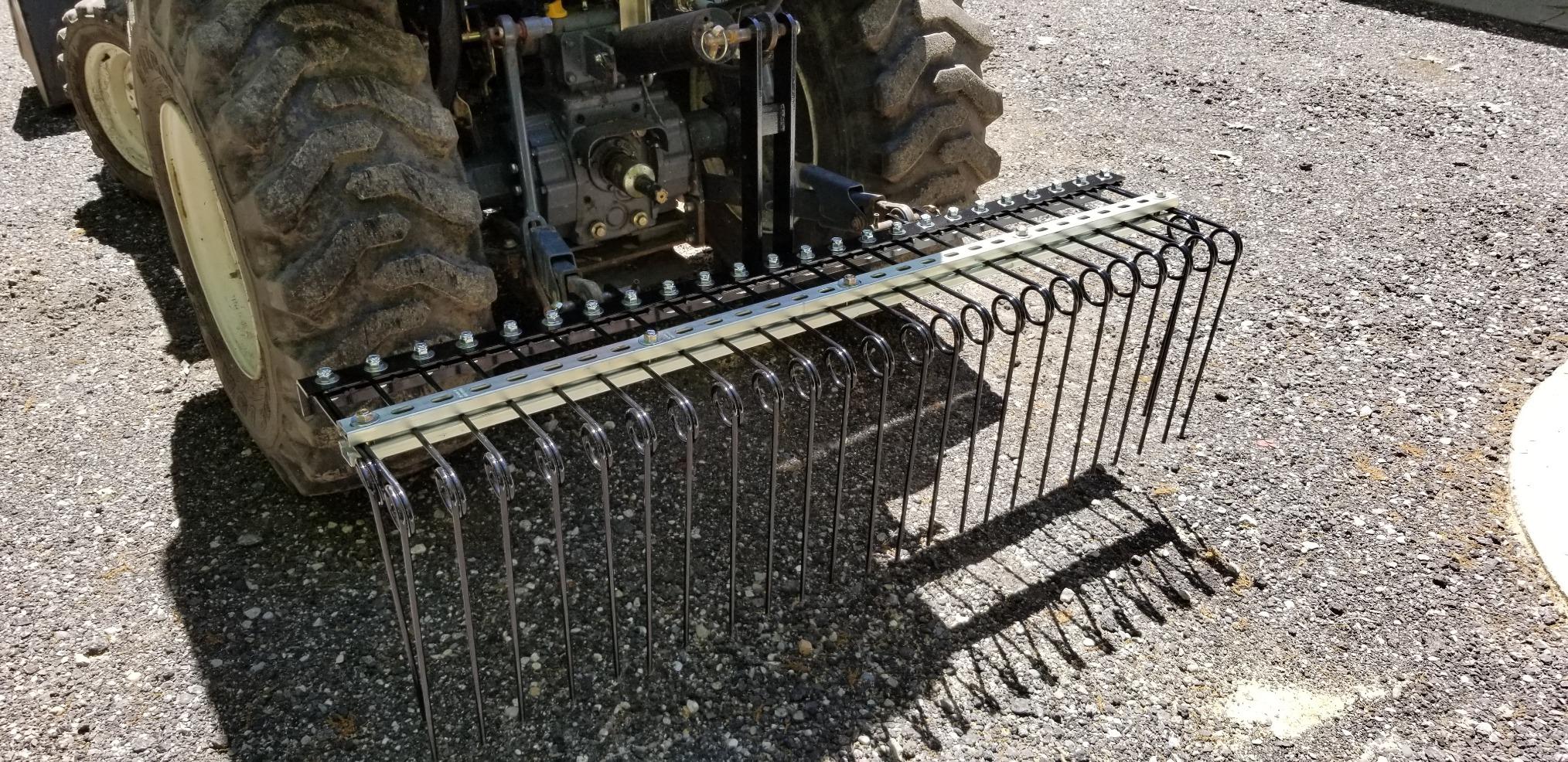 Field Tuff spring coil tine rake mounted to a tractor 3-point hitch on gravel